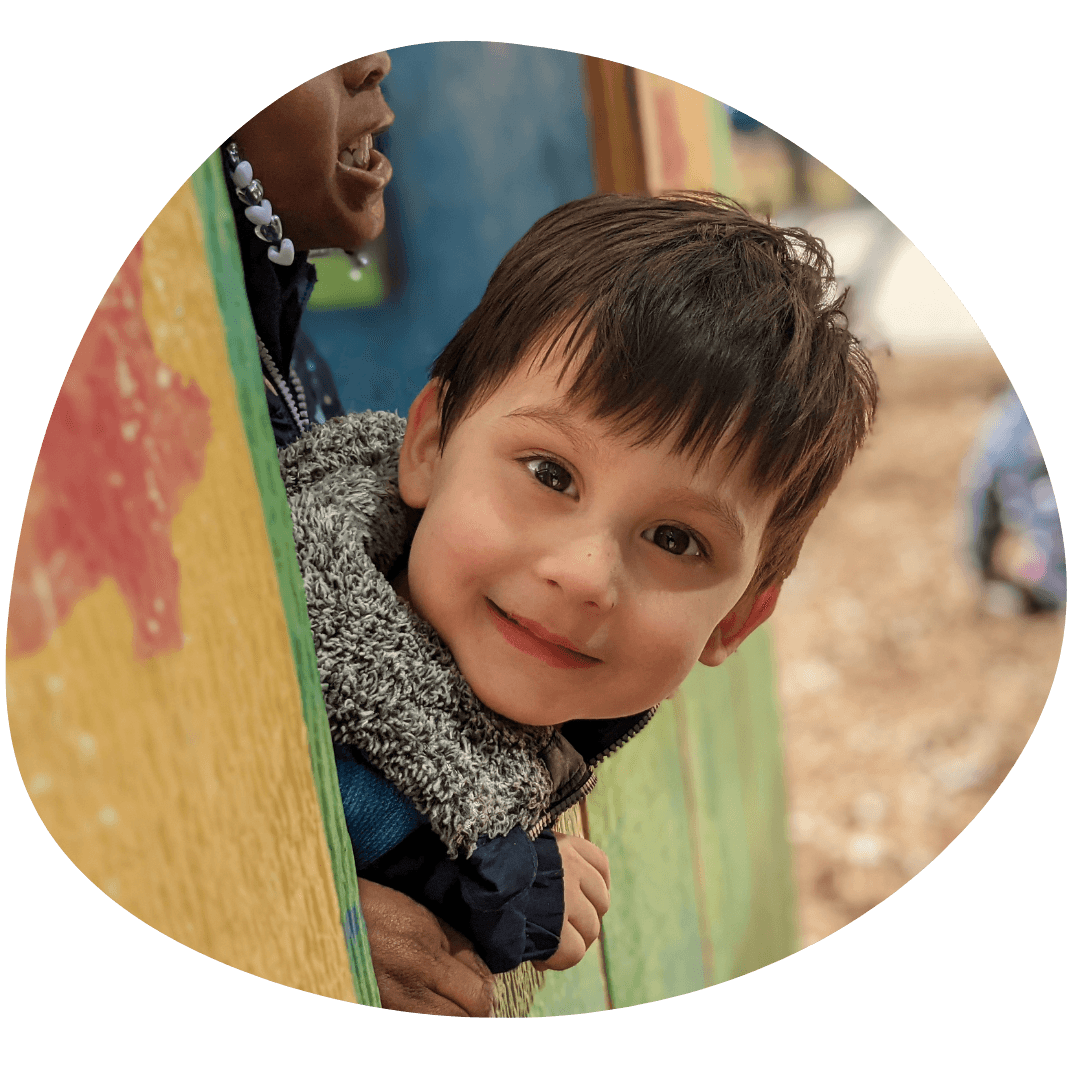 Smiling woman giving a piggyback ride to a laughing young girl.